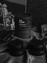 OLPHACTORY CANDLES. The Monk from The Quartet Discovery Collection. Four 4oz. Matte Black Tins in the Tribal print design tube. Front view.